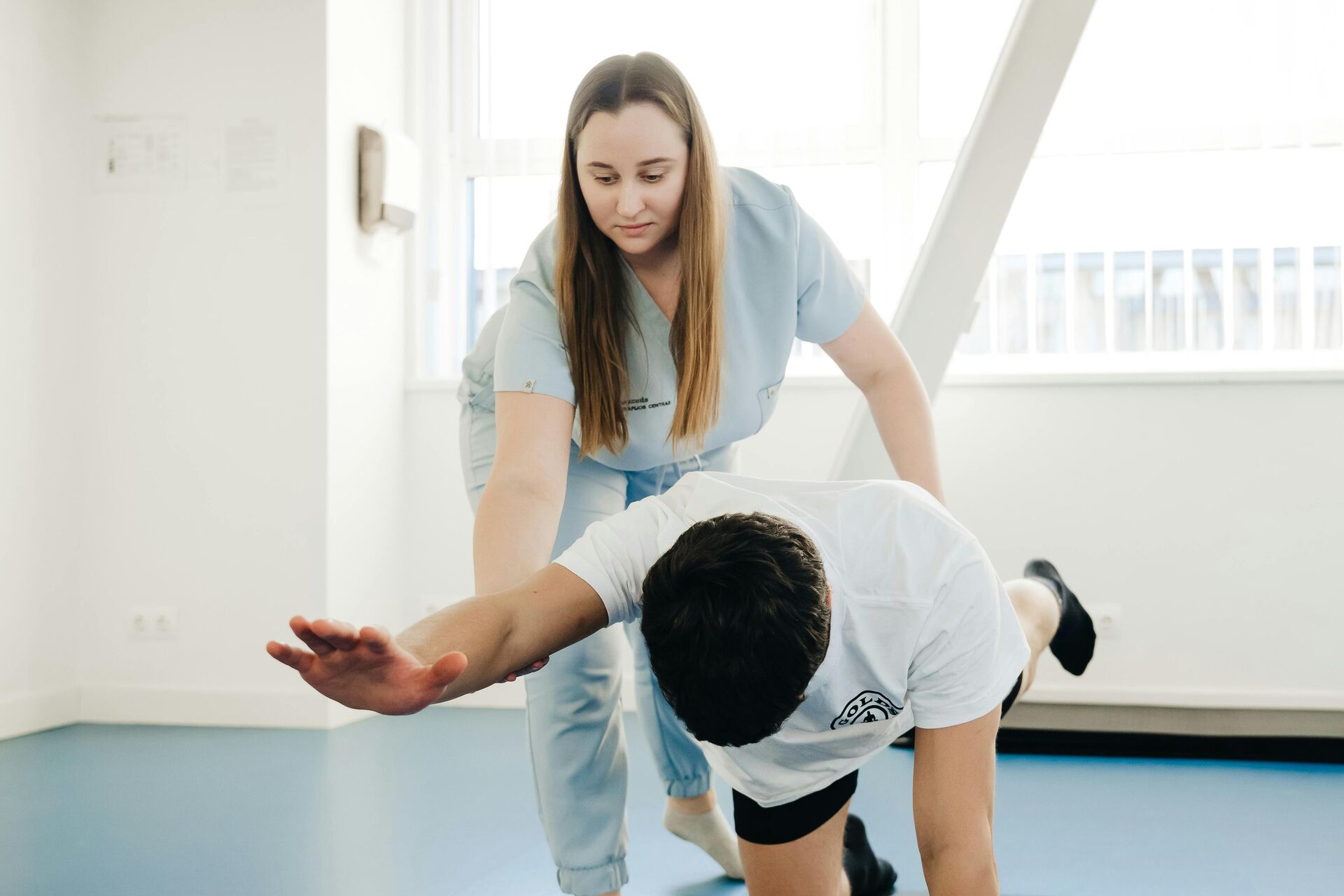 Physiotherapeutin begleitet einen Patienten bei einer Übung